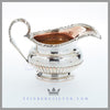 Feinberg Silver | The round, 1/2 fluted creamer has an applied gadroon and shell border and an acanthus loop handle.