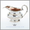 Feinberg Silver | The round, 1/2 fluted creamer has an applied gadroon and shell border and an acanthus loop handle. 