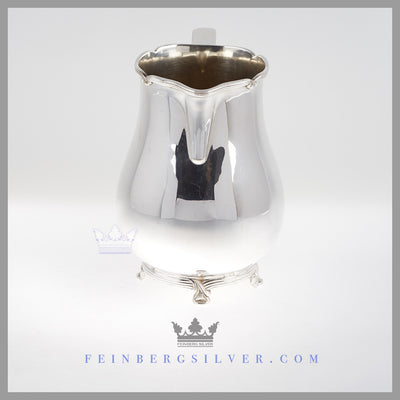 The pear shaped silver plated pitcher is on a cast thread and ribbon rim and foot. Feinberg Silver