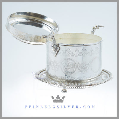 The unusual, round antique English silver plated biscuit box has an indentation on the lid to hold a flat bottom decanter. Feinberg Silver