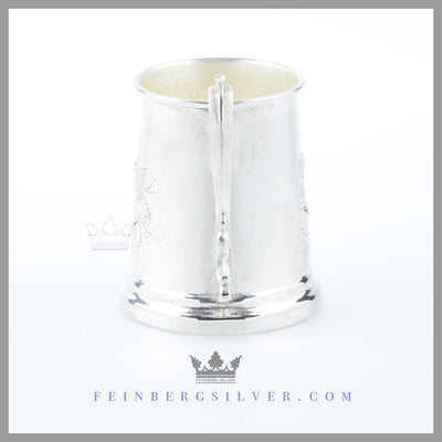 The Antique English Silver Child's Mug's tapered vertical body has a stepped rim foot and has a cast double scroll handle.