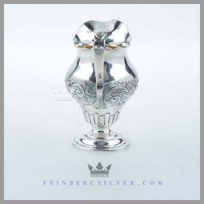 The Antique English Silver Geo III Style Cream Pitcher is baluster form and hand chased. Feinberg Silver